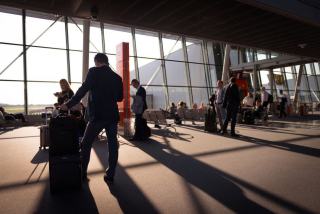 Combien de temps avant un vol faut-il arriver à l'aéroport Panneau d'affichage des départs et horloge dans un hall d'aéroport